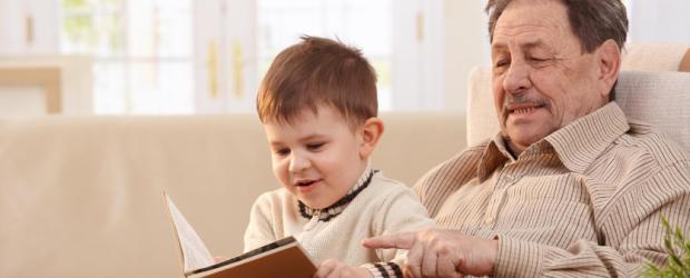 Ein Großvater ließt seinem kleinen Enkel aus einem Buch vor