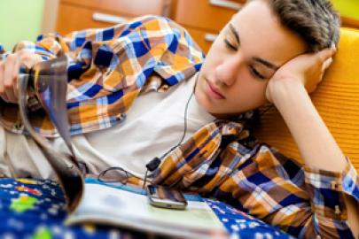 Teenager liest und hört Musik