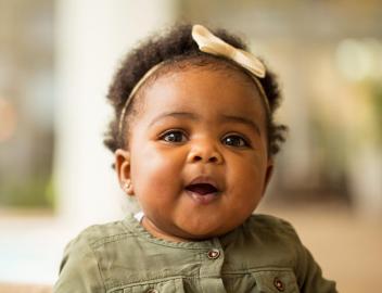 Ein kleines Mädchen schaut in die Kamera.